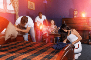 Group of young people searching for clues in lantern-lit bedroom