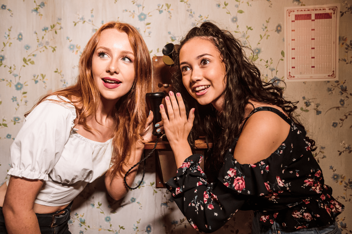 two girls in an escape room listening for a clue