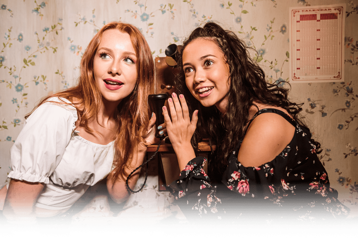 Two girls listening a for a clue in an escape room