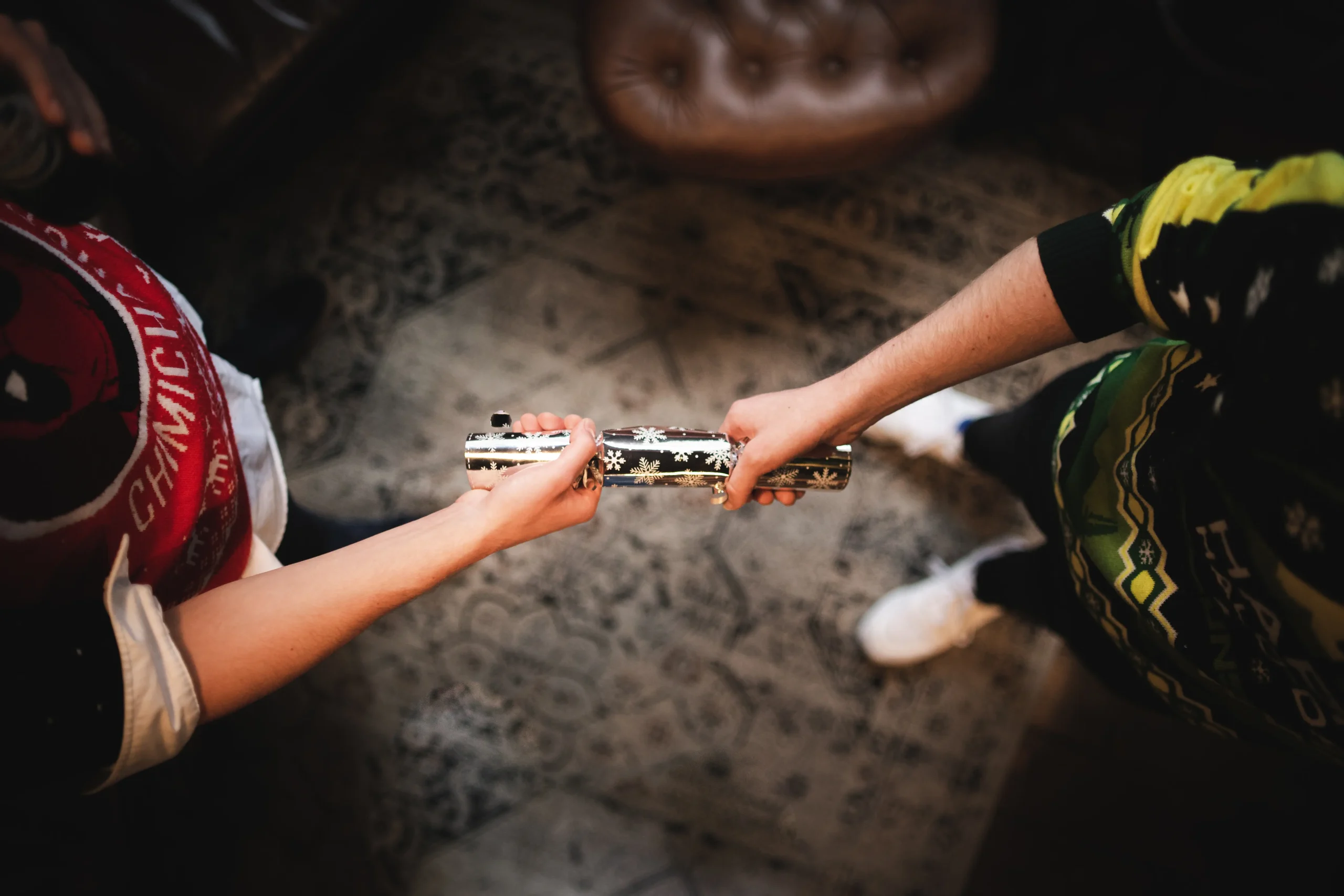 2 people holding a christmas cracker
