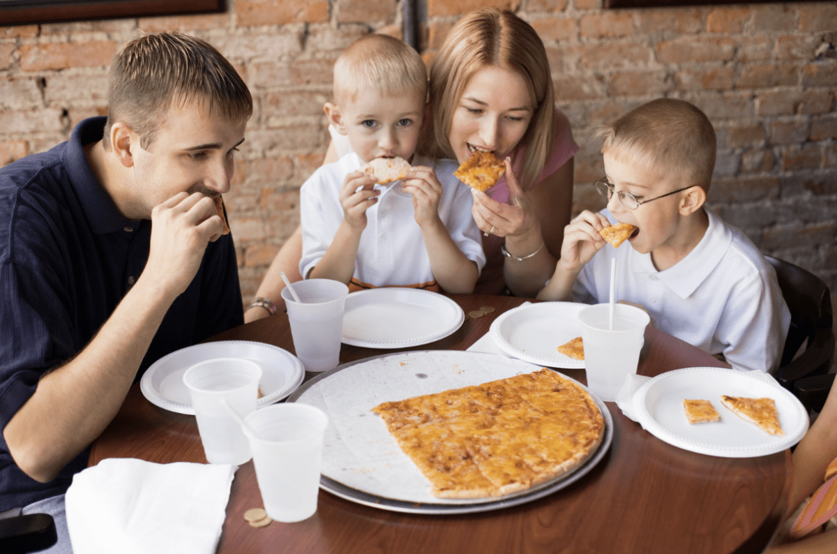 family sharing pizza in a restaurant