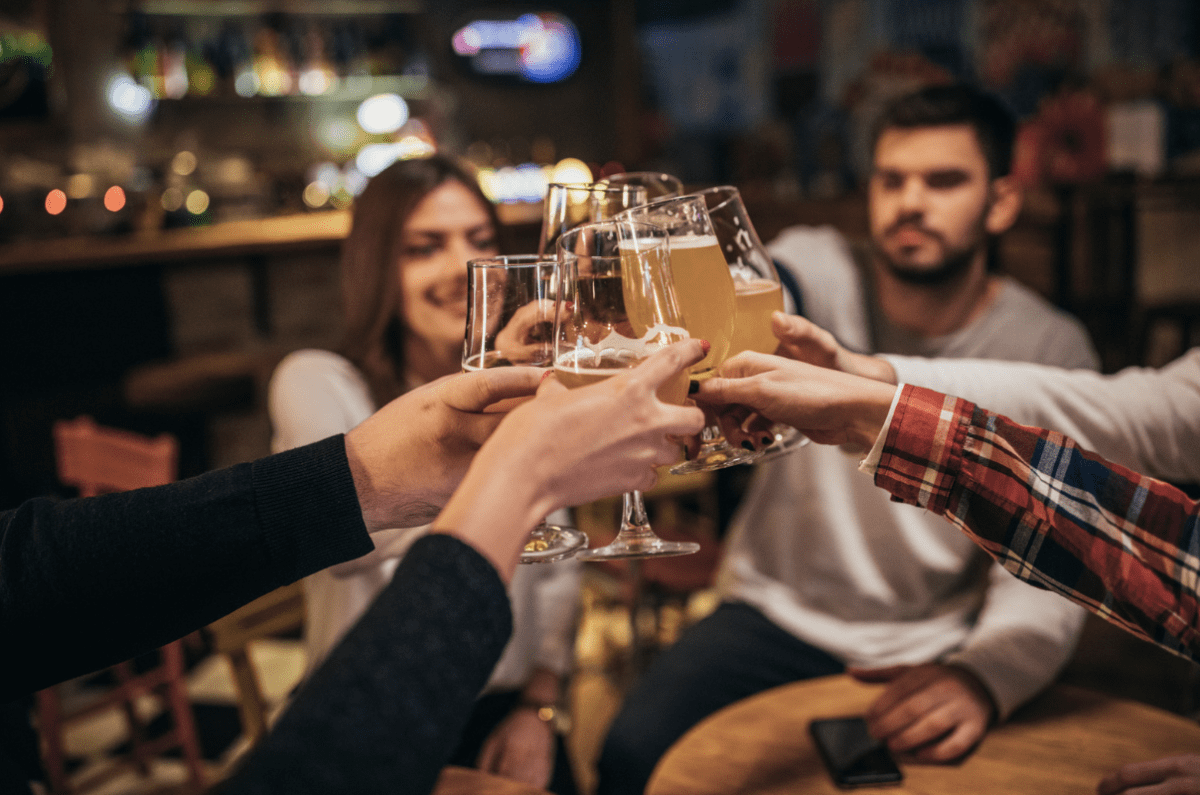 friends clinking glasses at a pub table