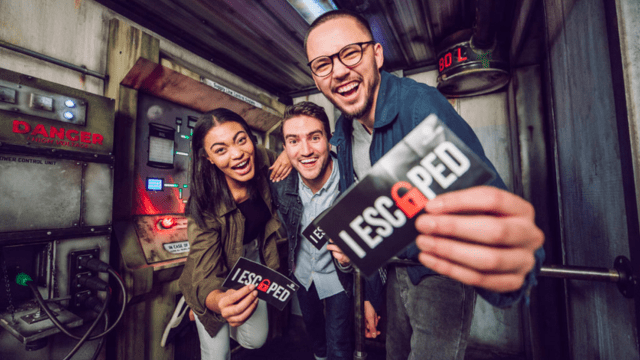 group of 3 people completing an escape room happy they escaped the heat